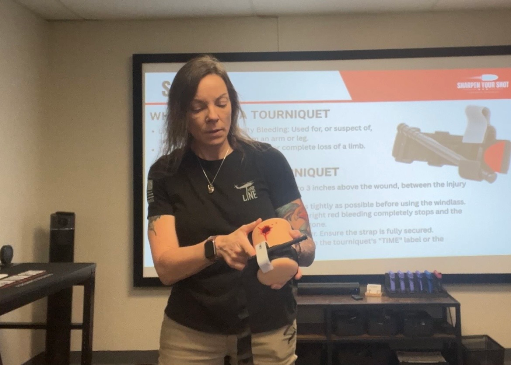 Firearms instructor demonstrating how to use a tourniquet during a safety training class
